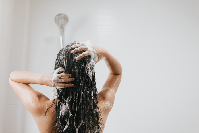 Woman washing hair with Detritus Shampoo and shower in bathroom