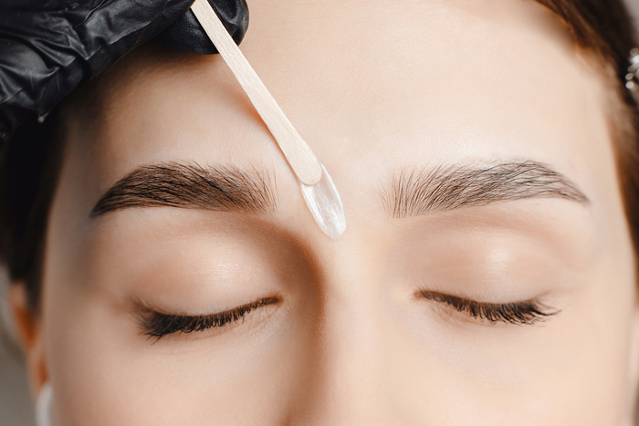 Master wax depilation of eyebrow hair in women